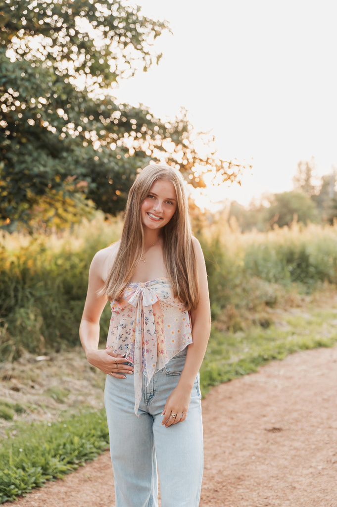 Picture of student standing on a gravel road in front of greenery