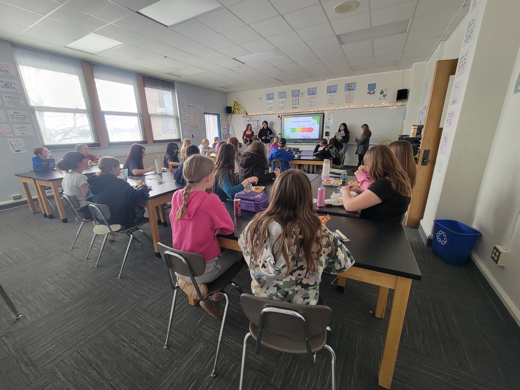 Students in a classroom sitting at desks looking to the front