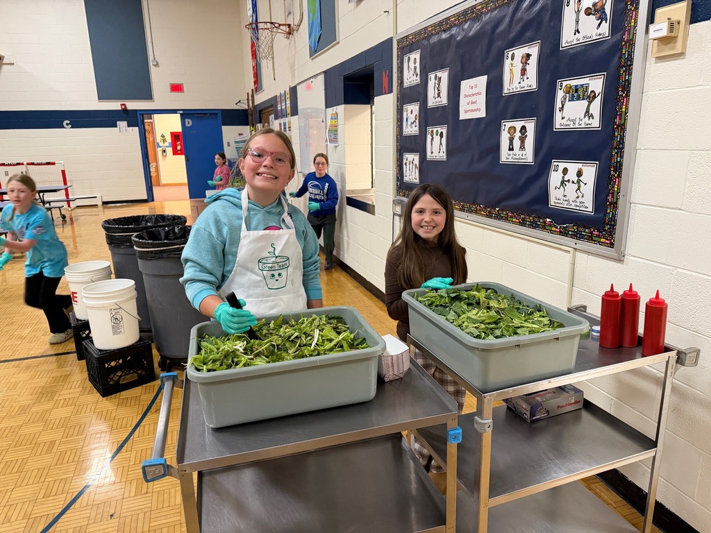 Two students serving fresh grown lettuce in the lunch line