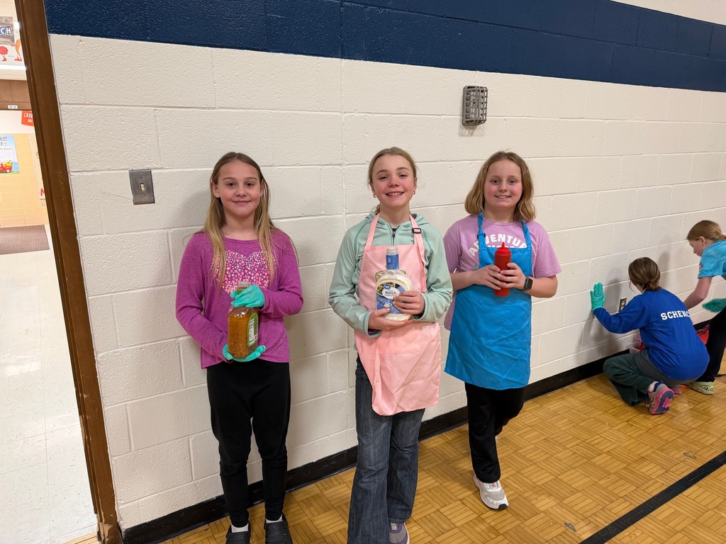 Three students holding condiment bottles in the lunch line