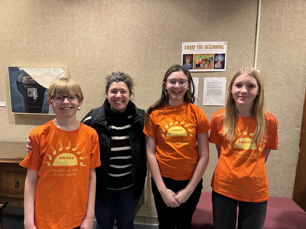 Three students in orange shirts pictured  with their teacher
