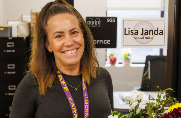 Smiling female employee with STAFF lanyard around neck