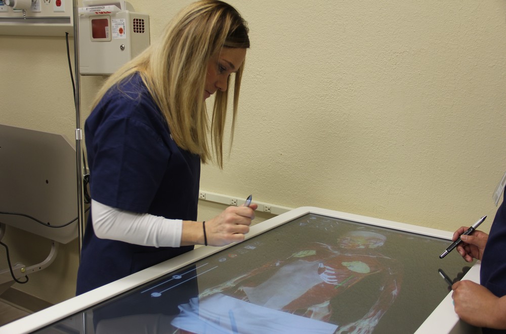Nursing students doing a digital operation on a large screen