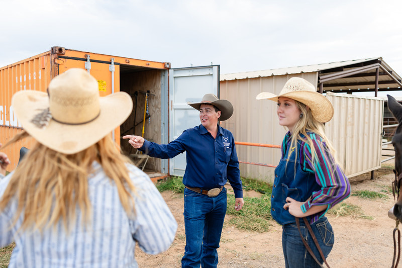 Mesalands rodeo team standing with the coach in the middle