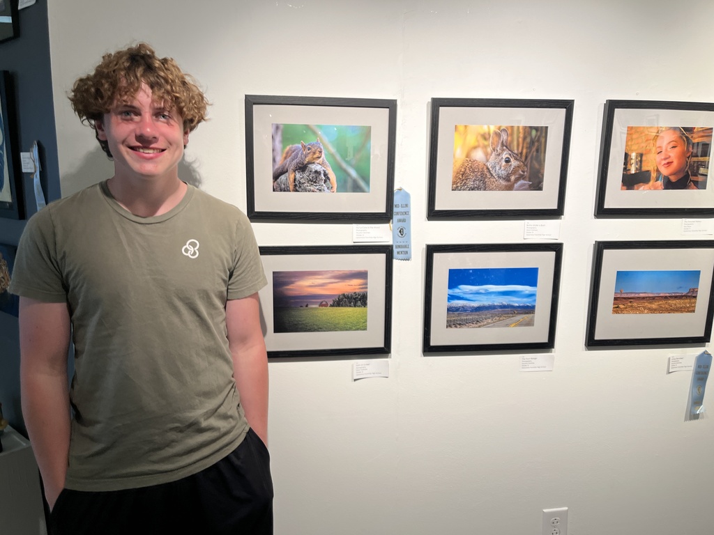Grant Oatman with some of his photos at the MI Art Show.