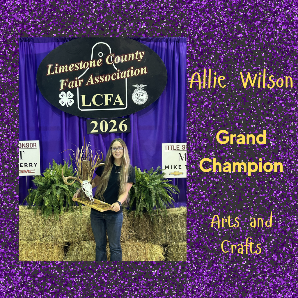 a female student showing off her sculpture of a goat head with brown foliage