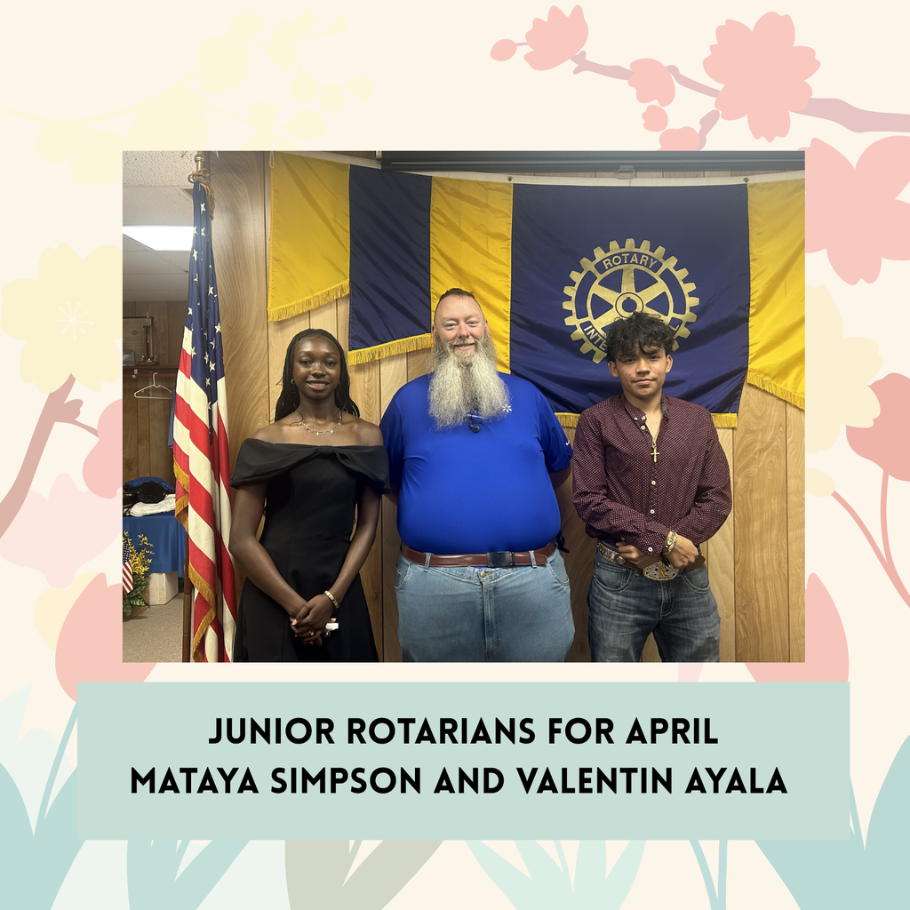 2 students posing with Rotarian representive in front of rotarian flag