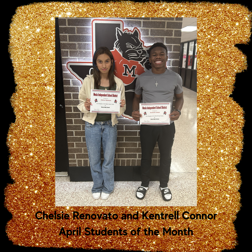Two students stand before a brick wall, each holding a certificate. One wears a jacket, jeans, and white shoes. The other wears a gray shirt, black pants, and sneakers.