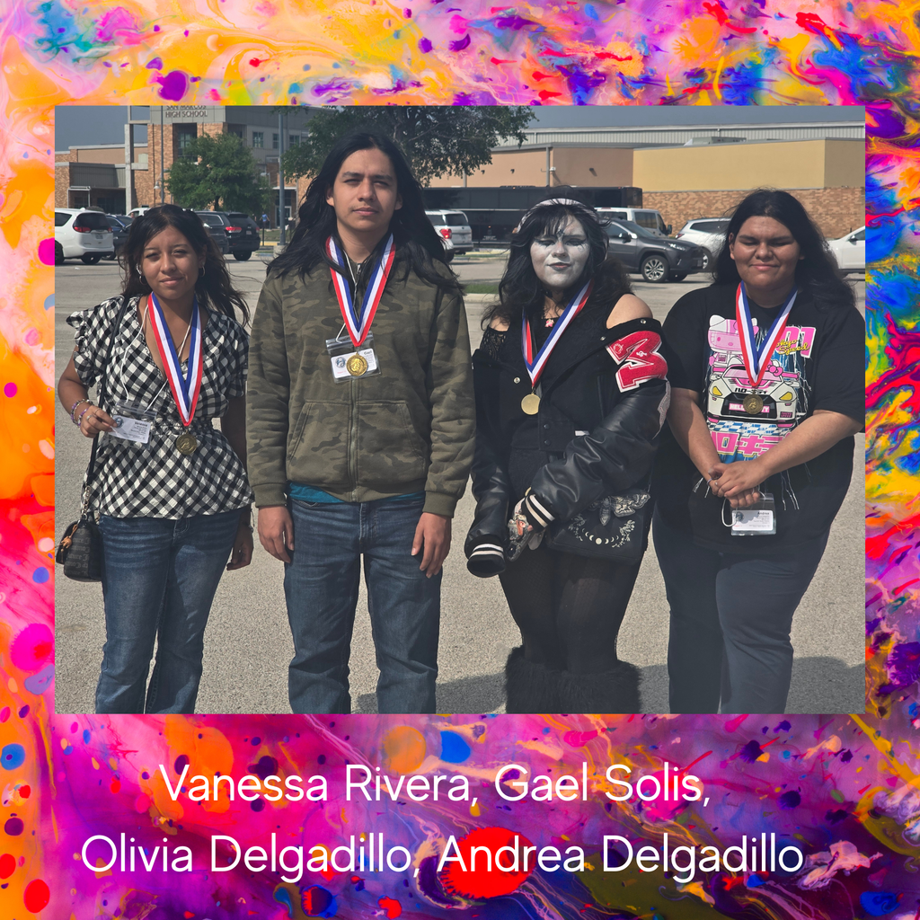 Four people stand in a row with colorful backgrounds. They wear medals around their necks. Behind them is a blurry parking lot with cars and a building.