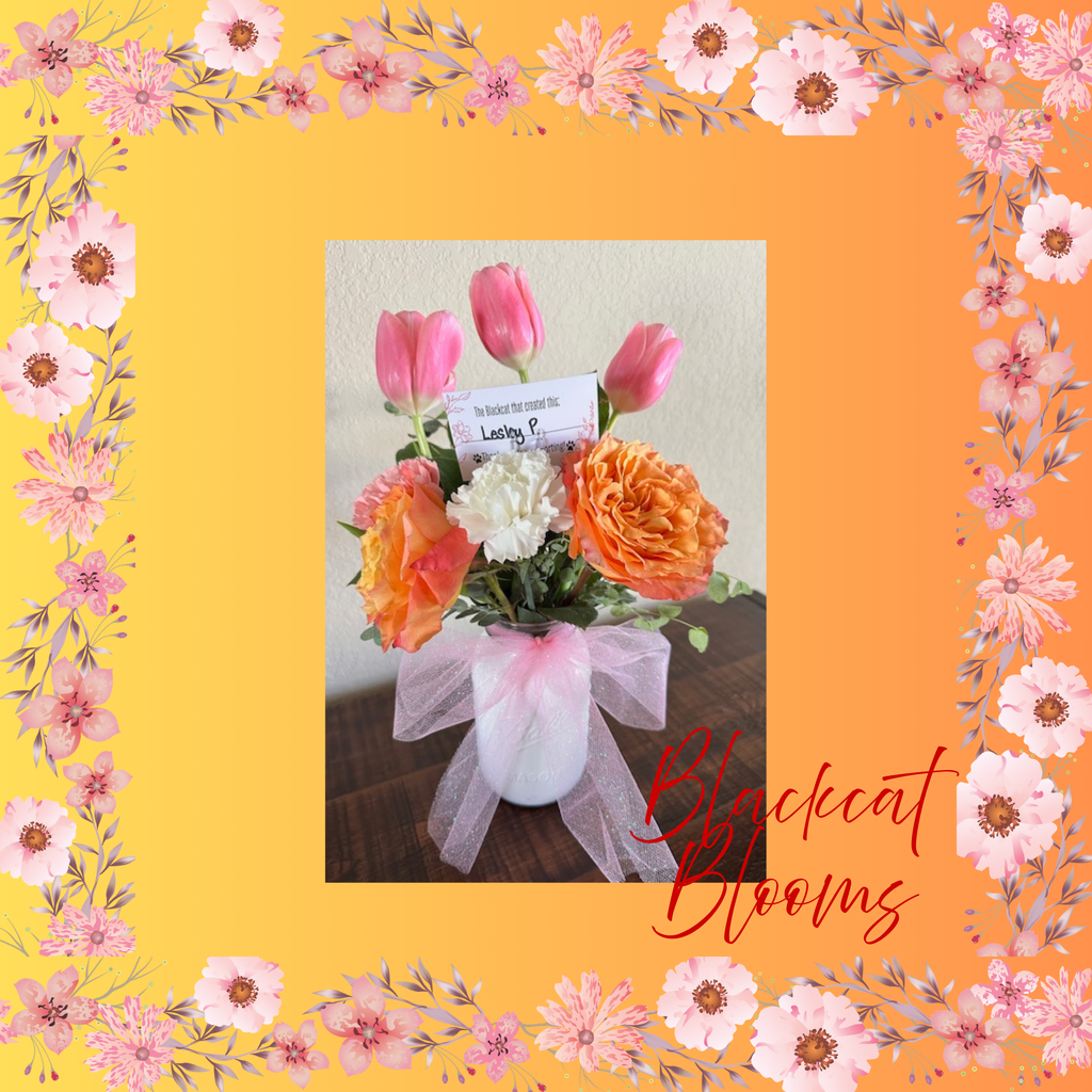 A floral arrangement of pink, orange, and white flowers in a white vase. Text reads "Blackcat Blooms".