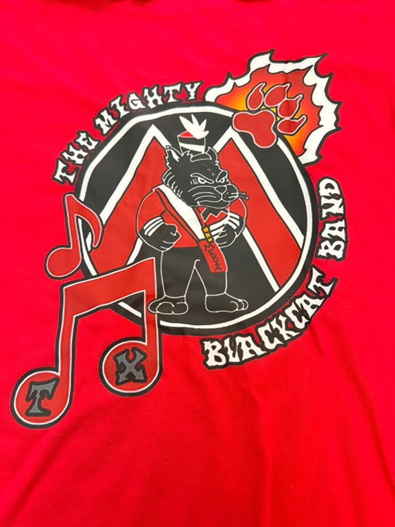 Red t-shirt with "The Mighty Blackcat Band" logo. Features musical notes, a mascot in a red uniform, and a paw print.