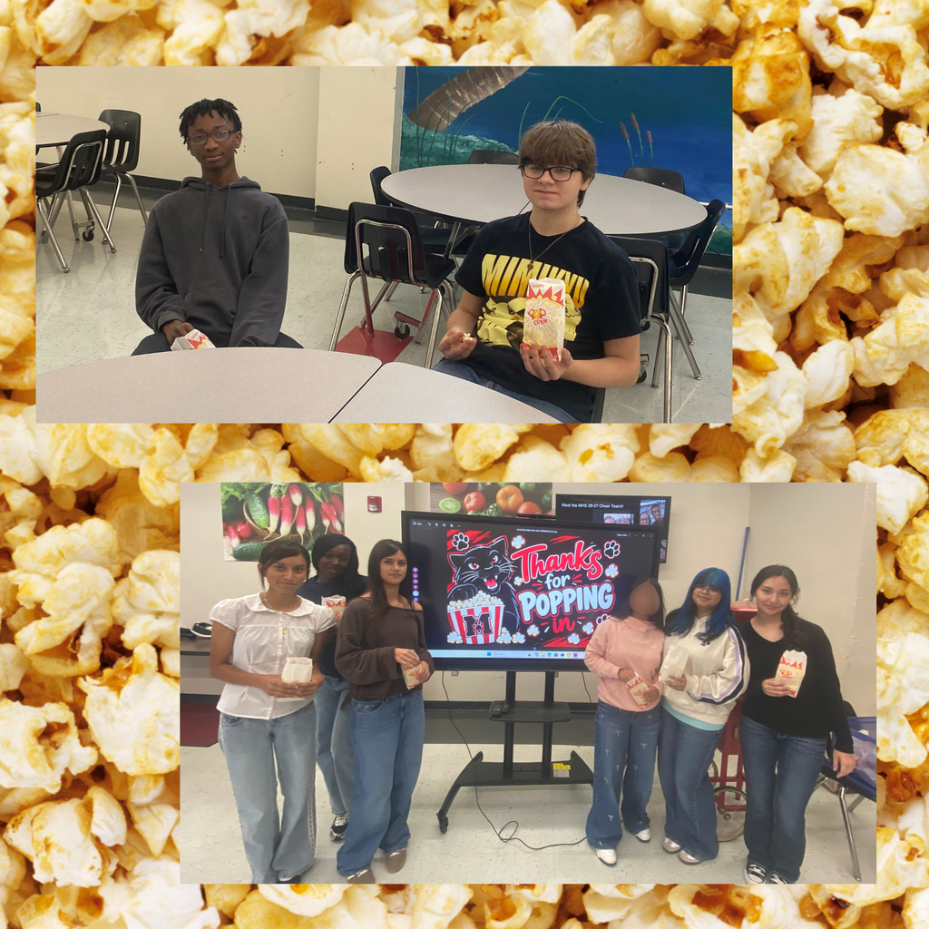 Multiple individuals holding popcorn boxes in front of a monitor displaying a movie title. Background shows classroom tables and chairs.