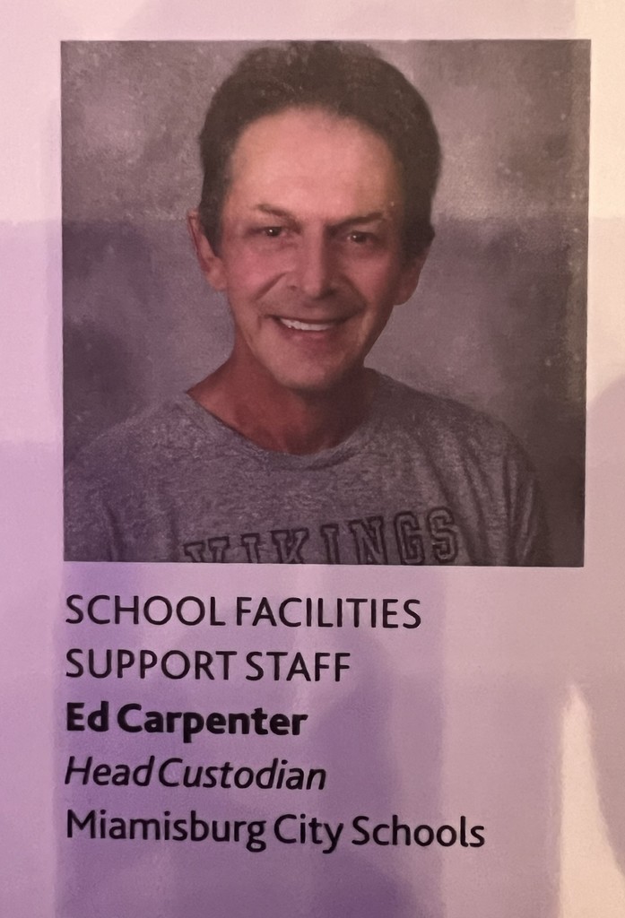 Portrait of a man wearing a gray shirt with text reading "SCHOOL FACILITIES SUPPORT STAFF Ed Carpenter Head Custodian Miamisburg City Schools".