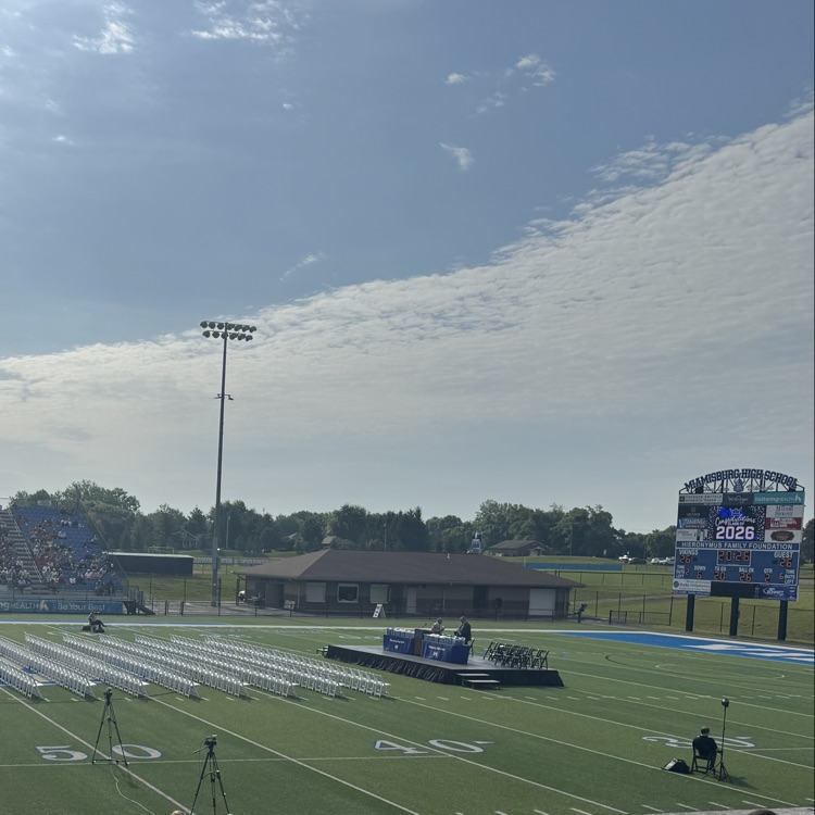 football field with stage and seats set up for graduation