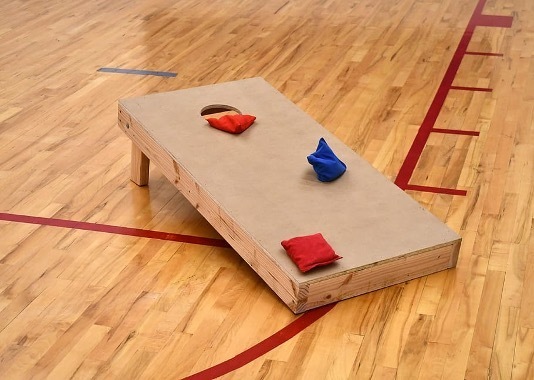 Cornhole board on a gym floor