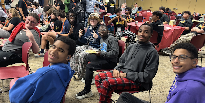 Esports team among a crowd sitting and watching the finals