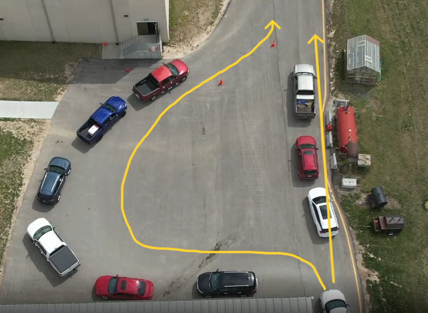 The back parking lot with yellow arrows showing how cars line up to load and unload students in the am and pm