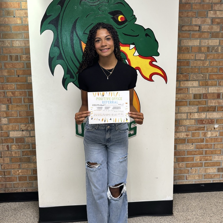 girl holding a certificate with a dragon in the background