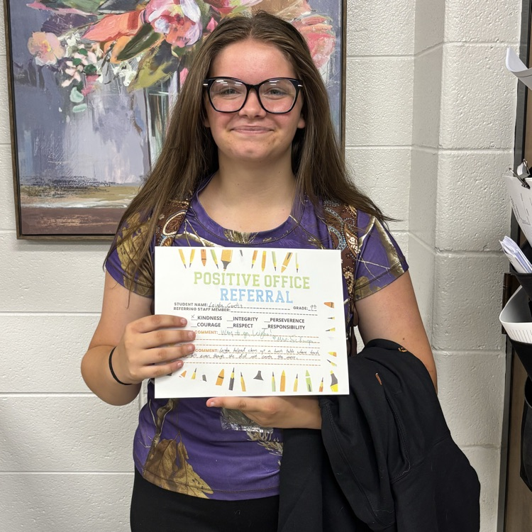girl holding a certificate with a floral painting in the background