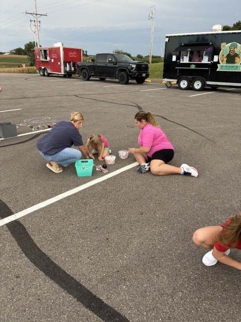 Two High School Students doing chalk with a younger student.