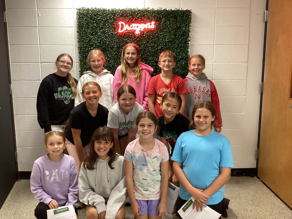 12 students in front of a LED Dragons sign