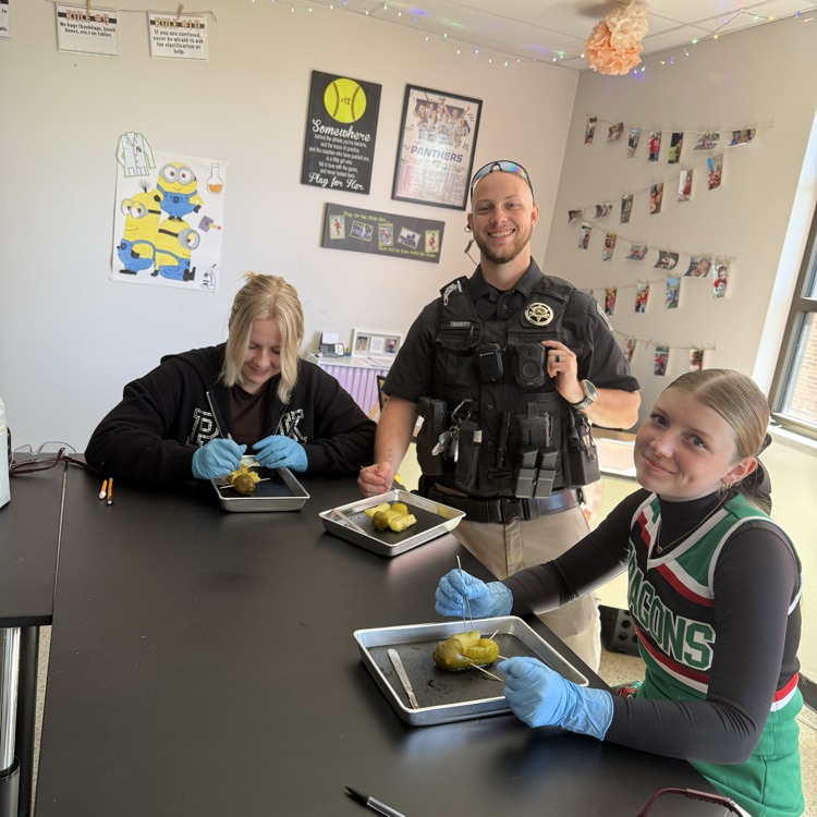 two students and the SRO practicing dissection on a pickle