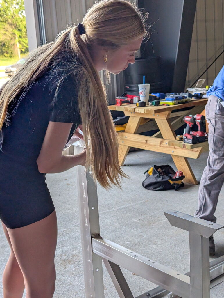 Students working to build metal bleachers