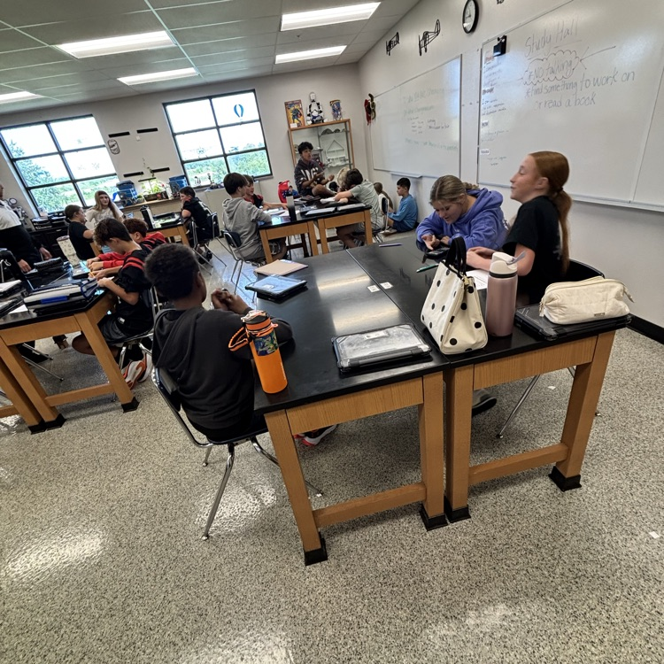  students sitting at a lab table in a science classroom