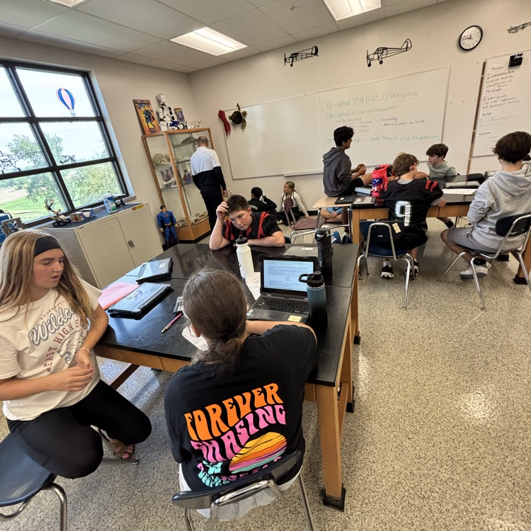 students sitting at a lab table in a science classroom