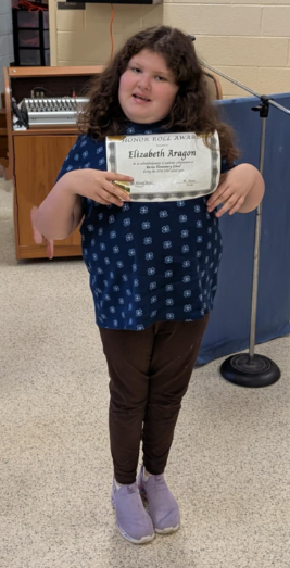 Image of student with honor roll award.