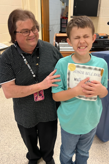 Image of student with honor roll award.