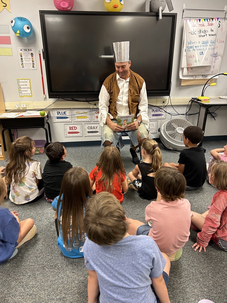 Pictures of Mr. Becker reading to 1st grade as Johnny Appleseed.