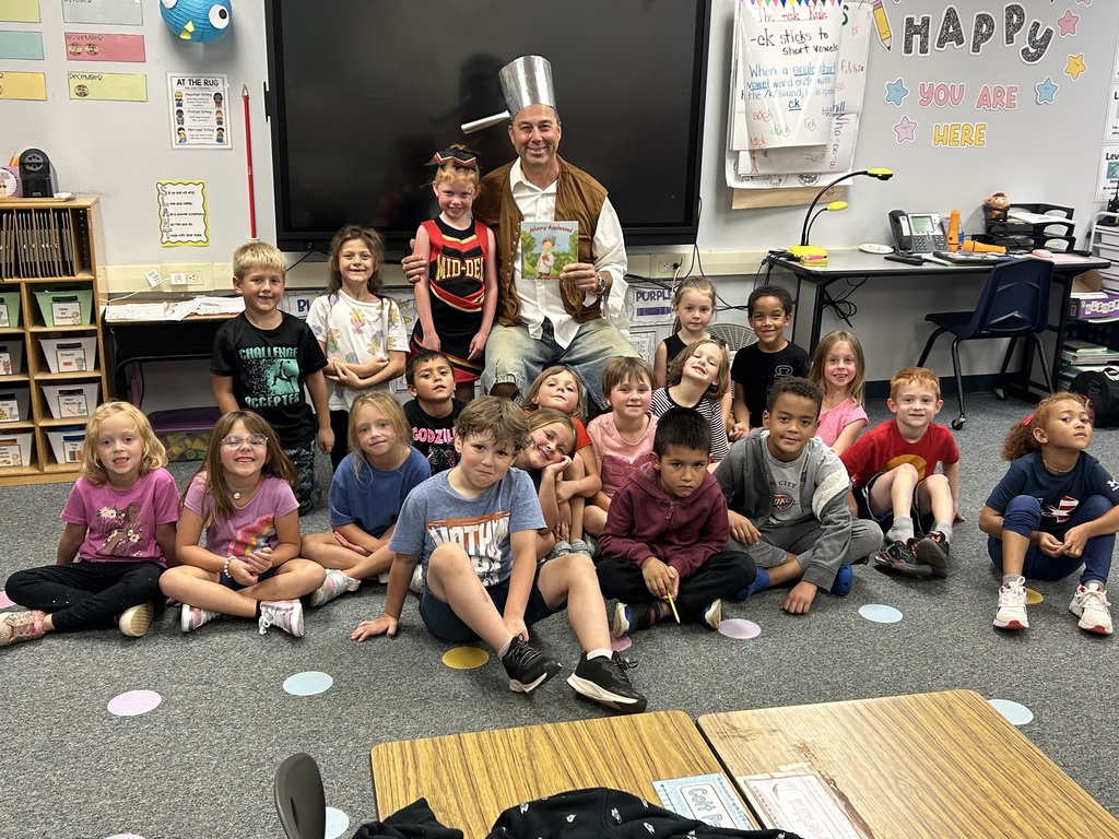 Pictures of Mr. Becker reading to 1st grade as Johnny Appleseed.