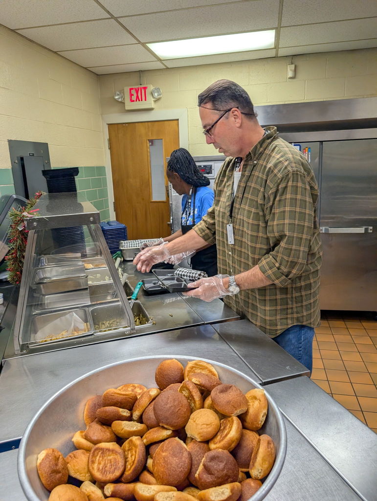 Mr. Becker serving food in the cafeteria.