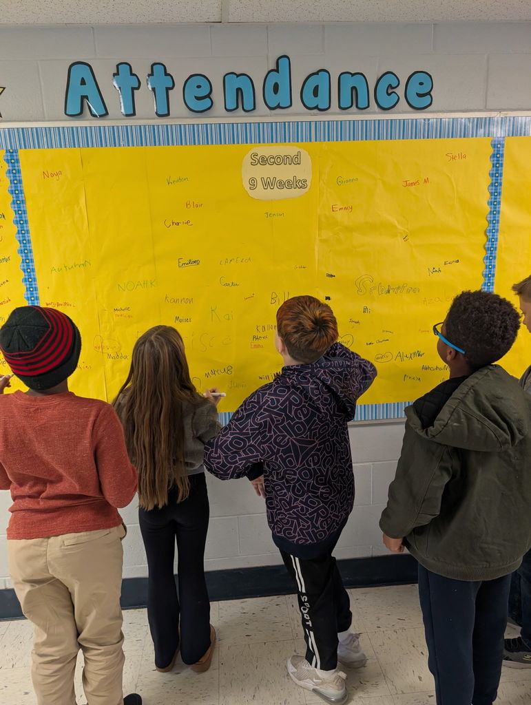 Image of students signing the Attendance Board.