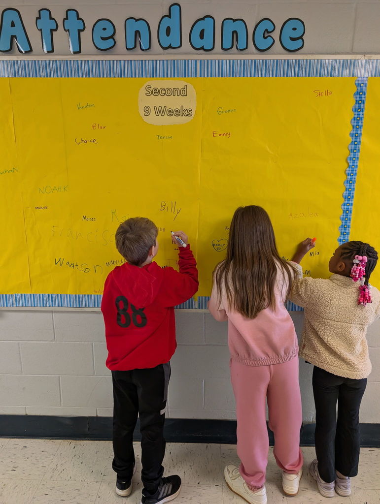 Image of students signing the Attendance Board.