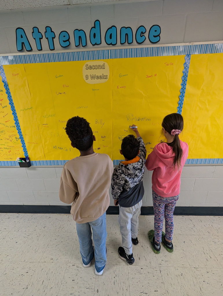 Image of students signing the Attendance Board.