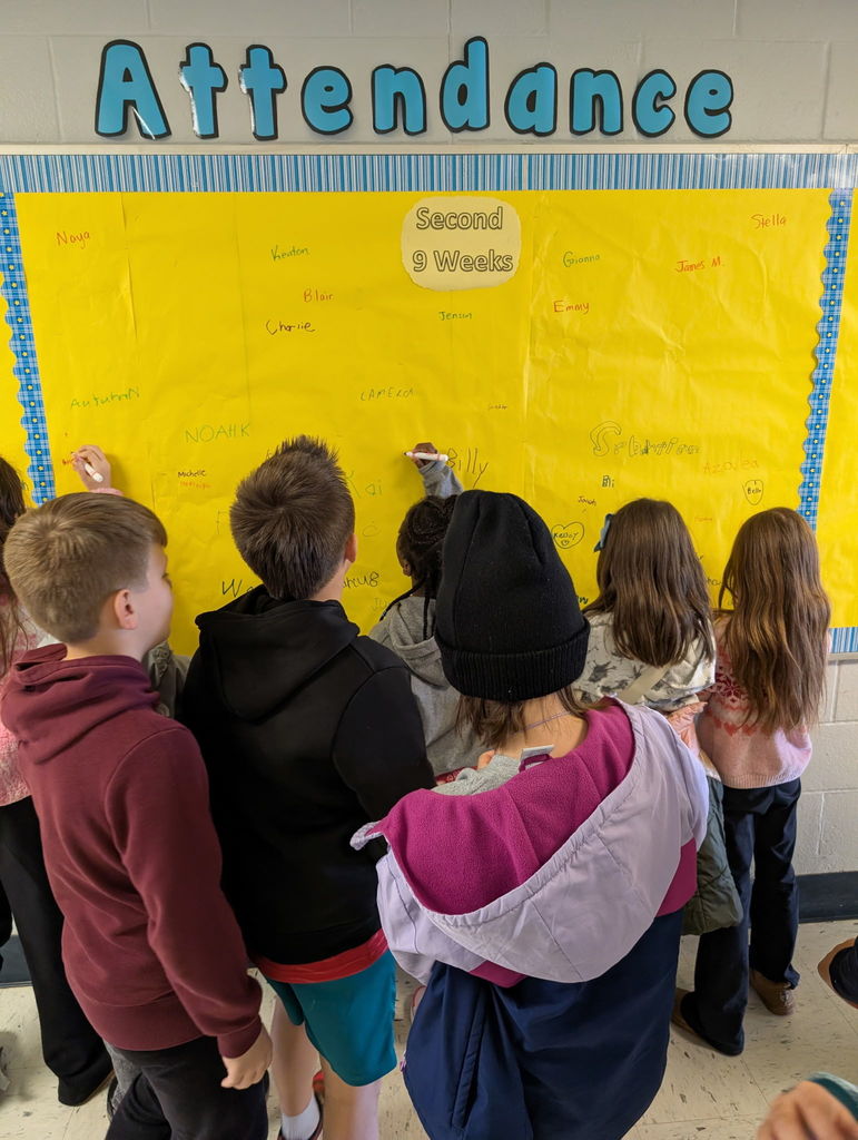Image of students signing the Attendance Board.
