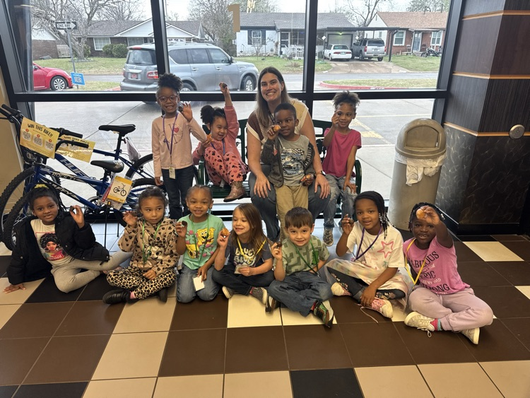 Celebrating growth! A group of kindergarten are excitedly holding up donut holes as a reward for their hard work on letters.