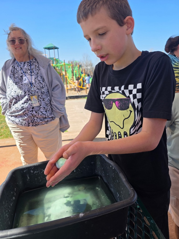   hands-on sensory activity for special education students. Children sticking their hands in a bucket of green slime for St. Patrick’s Day. 