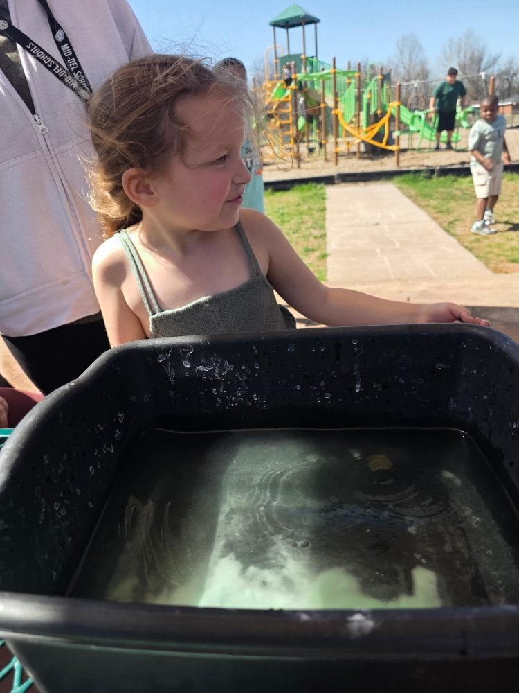  hands-on sensory activity for special education students. Children sticking their hands in a bucket of green slime for St. Patrick’s Day. 