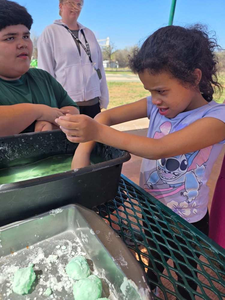  hands-on sensory activity for special education students. Children sticking their hands in a bucket of green slime for St. Patrick’s Day. 