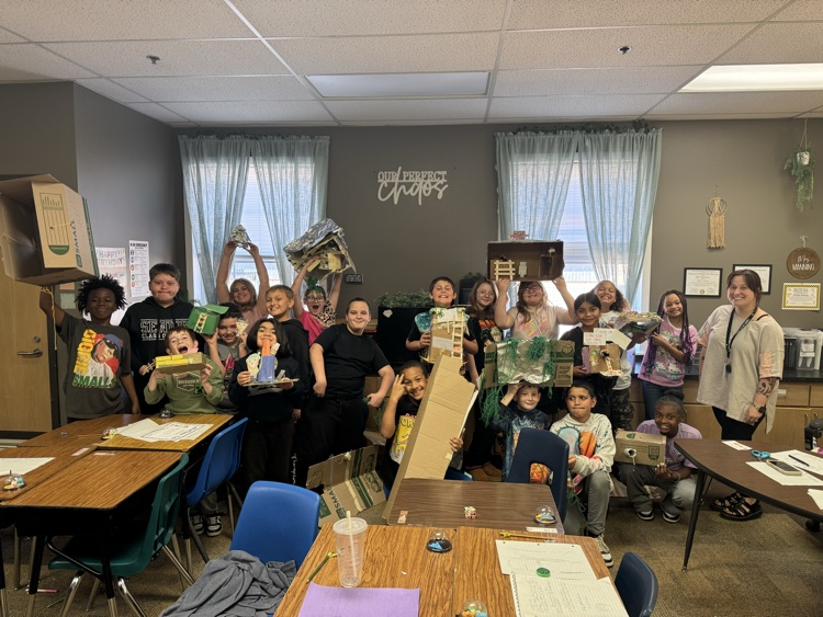 leprechaun traps made by fourth graders. The students are in front of the room, presenting them.