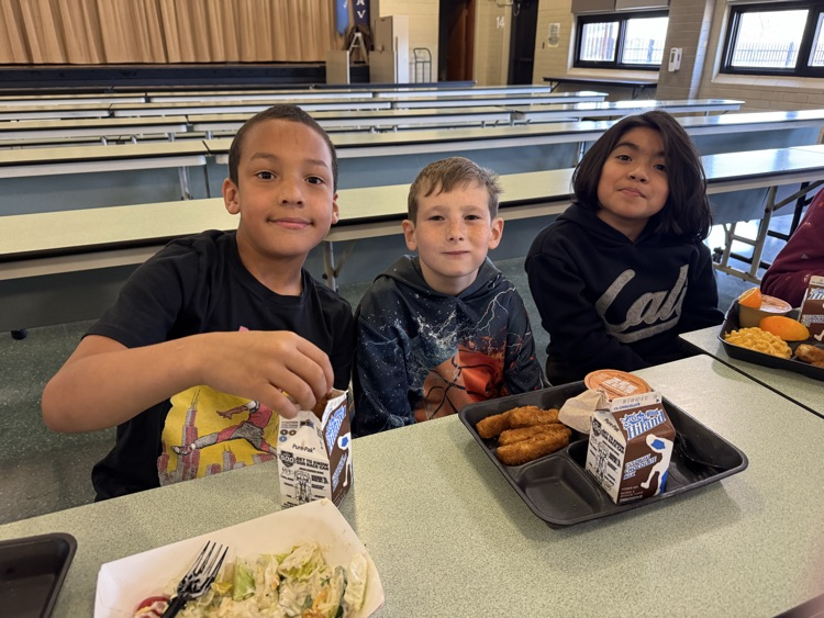 Photos of students in the cafeteria. Enjoying lunch, going through the line to grab a tray, and chatting with friends.