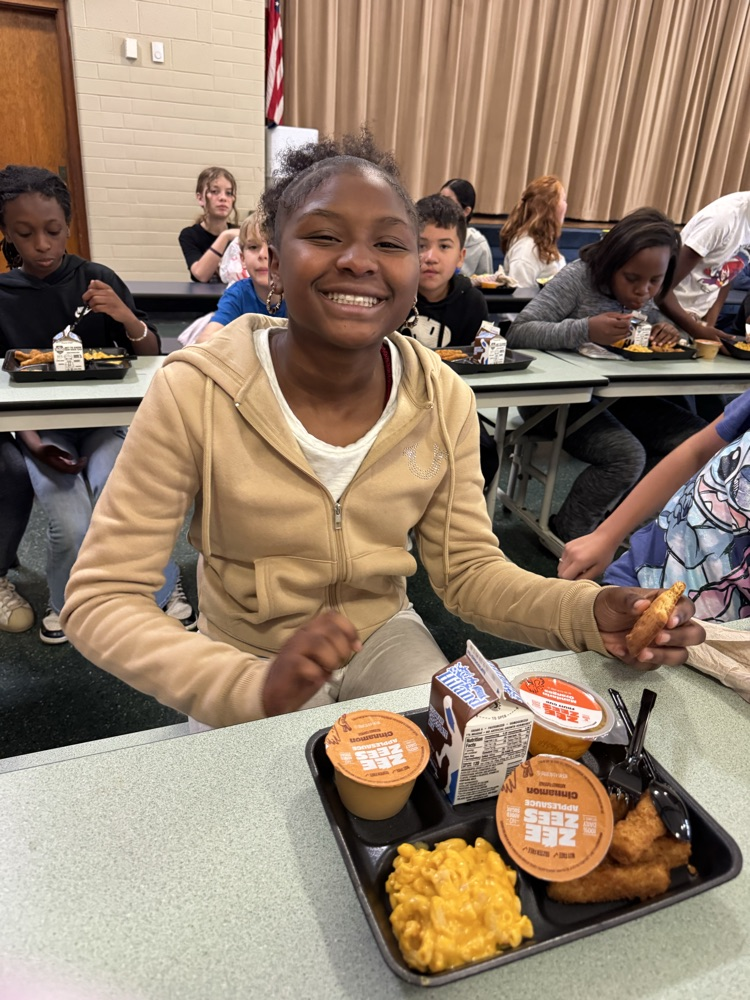 Photos of students in the cafeteria. Enjoying lunch, going through the line to grab a tray, and chatting with friends.