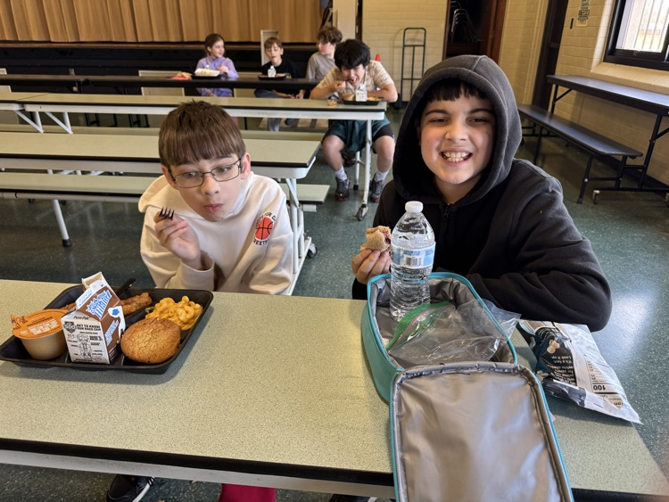 Photos of students in the cafeteria. Enjoying lunch, going through the line to grab a tray, and chatting with friends.