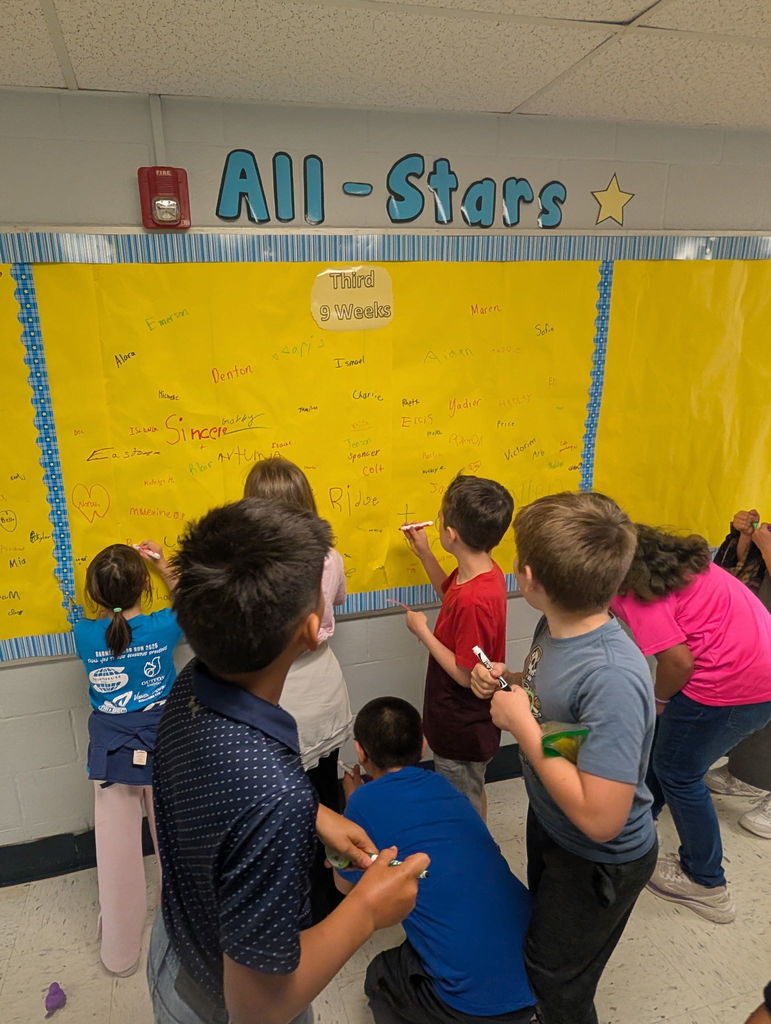 Barnes elementary students sign the Attendance All Stars Board in the hallway.