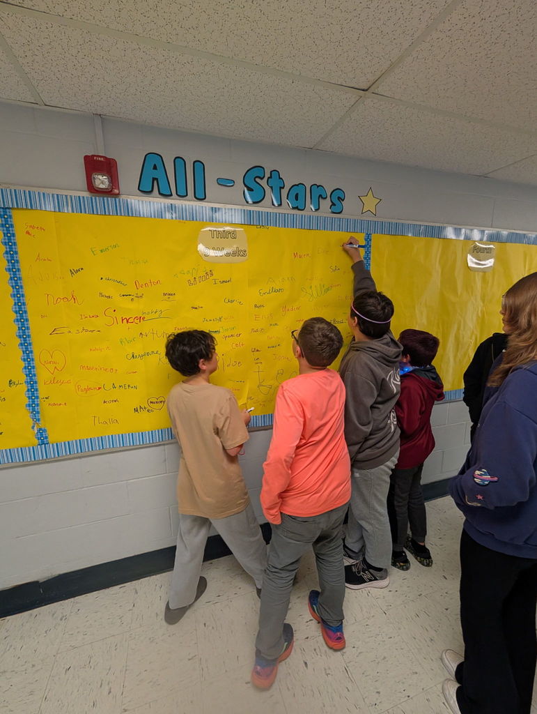 Barnes elementary students sign the Attendance All Stars Board in the hallway.