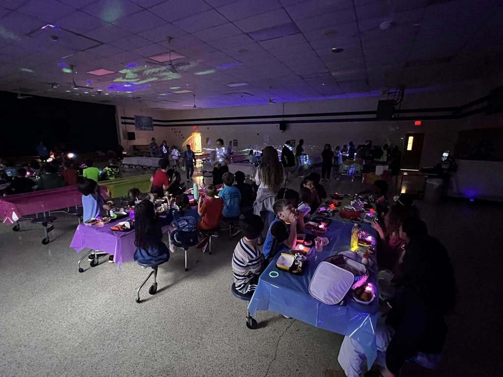 Barnes student having lunch while the glow lunch activities are going on around them.  