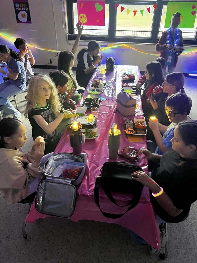 Barnes student having lunch while the glow lunch activities are going on around them.  